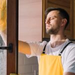 Hombre limpiando ventana de pvc