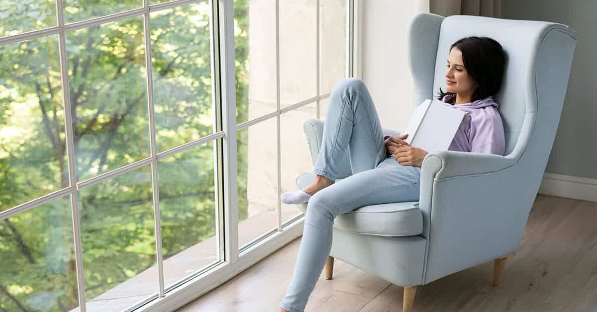 Mujer leyendo frente a la ventana